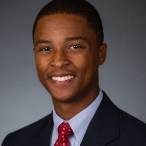 A person in formal attire smiling in a professional portrait.