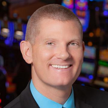 A person smiling with colorful background lights