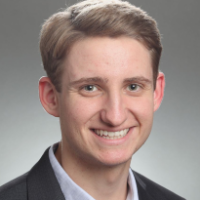 A person in a suit smiling.
