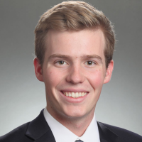 Smiling person in a suit with a tie.