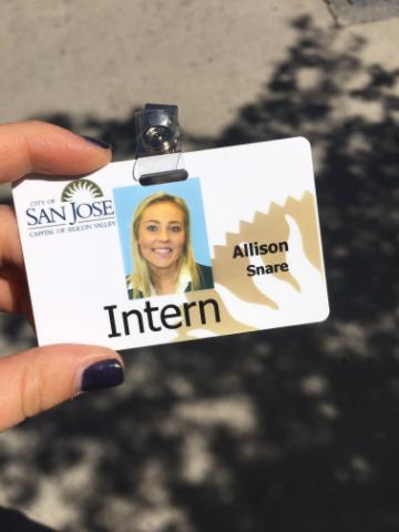 A hand holds an identification badge for the University of Dayton.