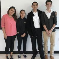 Four people standing in front of a whiteboard, titled 