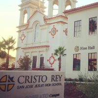 Alt text: Cristo Rey High School building with bell towers and 