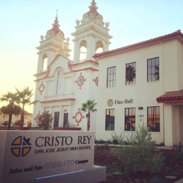 Alt text: Cristo Rey High School building with bell towers and 