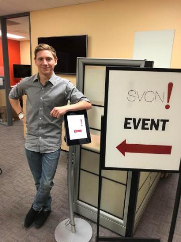 Man standing next to an event sign reading 