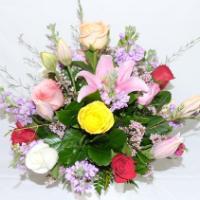 Colorful floral arrangement with various types of flowers against a white background.