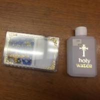 Alt text: Three small bottles on a wooden surface, including one with a cross symbol.