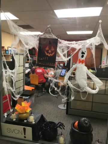 Halloween decorations with a large spiderweb in a room, various decorations around.