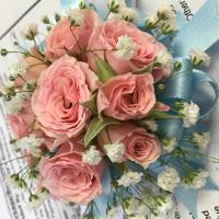 A bouquet of pink roses and white flowers on a table.