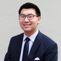 A man in a suit smiling.