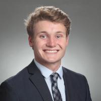 A person in a suit and tie smiling.