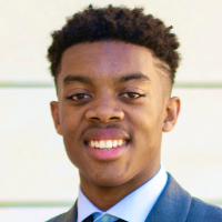 A man in a suit smiling at the camera.