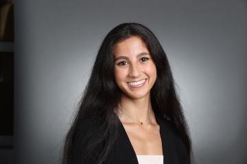 Smiling person against a gray background.