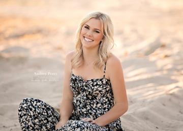 A person sitting outdoors in a patterned jumpsuit.