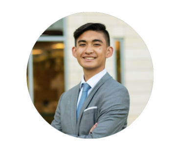 A person in a grey suit and blue tie.