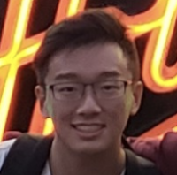 A person wearing glasses in front of illuminated text.