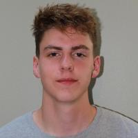 A person wearing a gray shirt against a plain background.