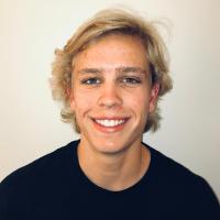 A person smiling at the camera against a plain background.