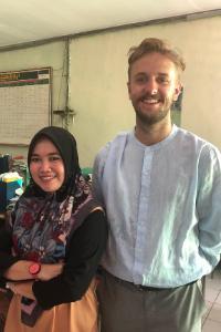 Two people smiling in an office environment.