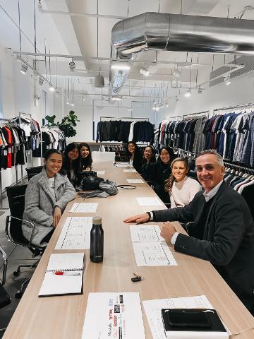 A large group of people sitting around a conference table in an office.