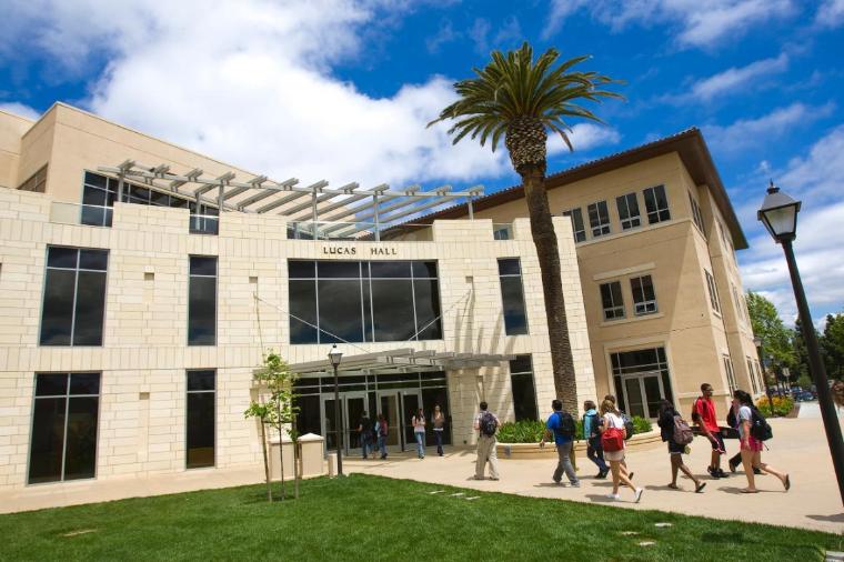Lucas Hall building with students walking outside under a blue sky.