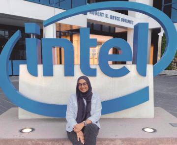 A person sitting in front of an Intel sign at Markkula Center.