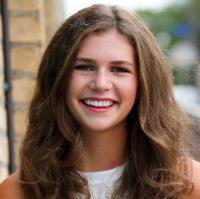 A person smiling in an outdoor setting.