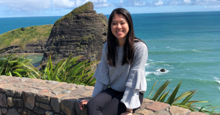 A person sitting on a stone wall with an ocean view background. image link to story