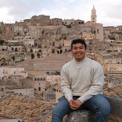 A person sitting with a cityscape in the background.