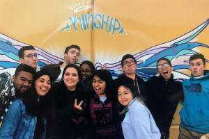 A group of people smiling under a yellow tent.
