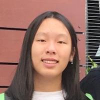 A person standing in front of a red wall.