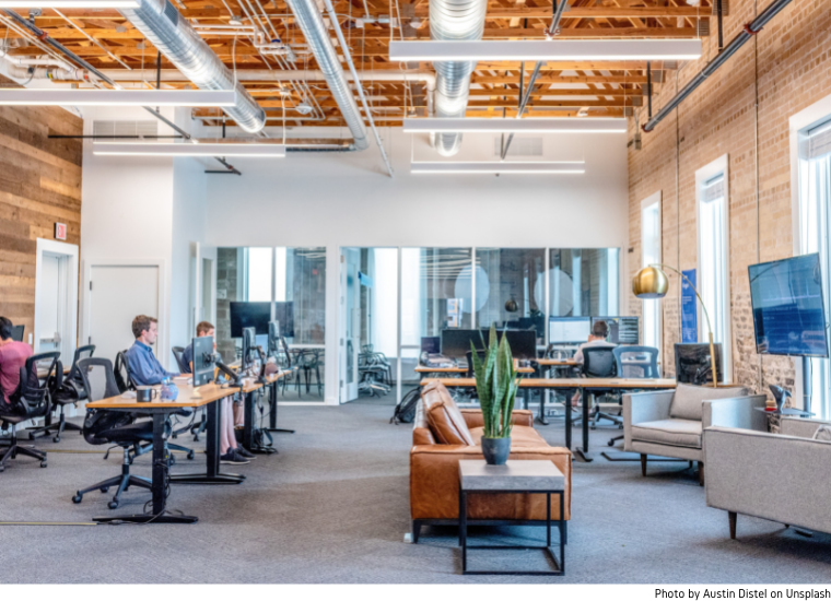 Photo of open coworking space with desks, meeting room, and people. image link to story