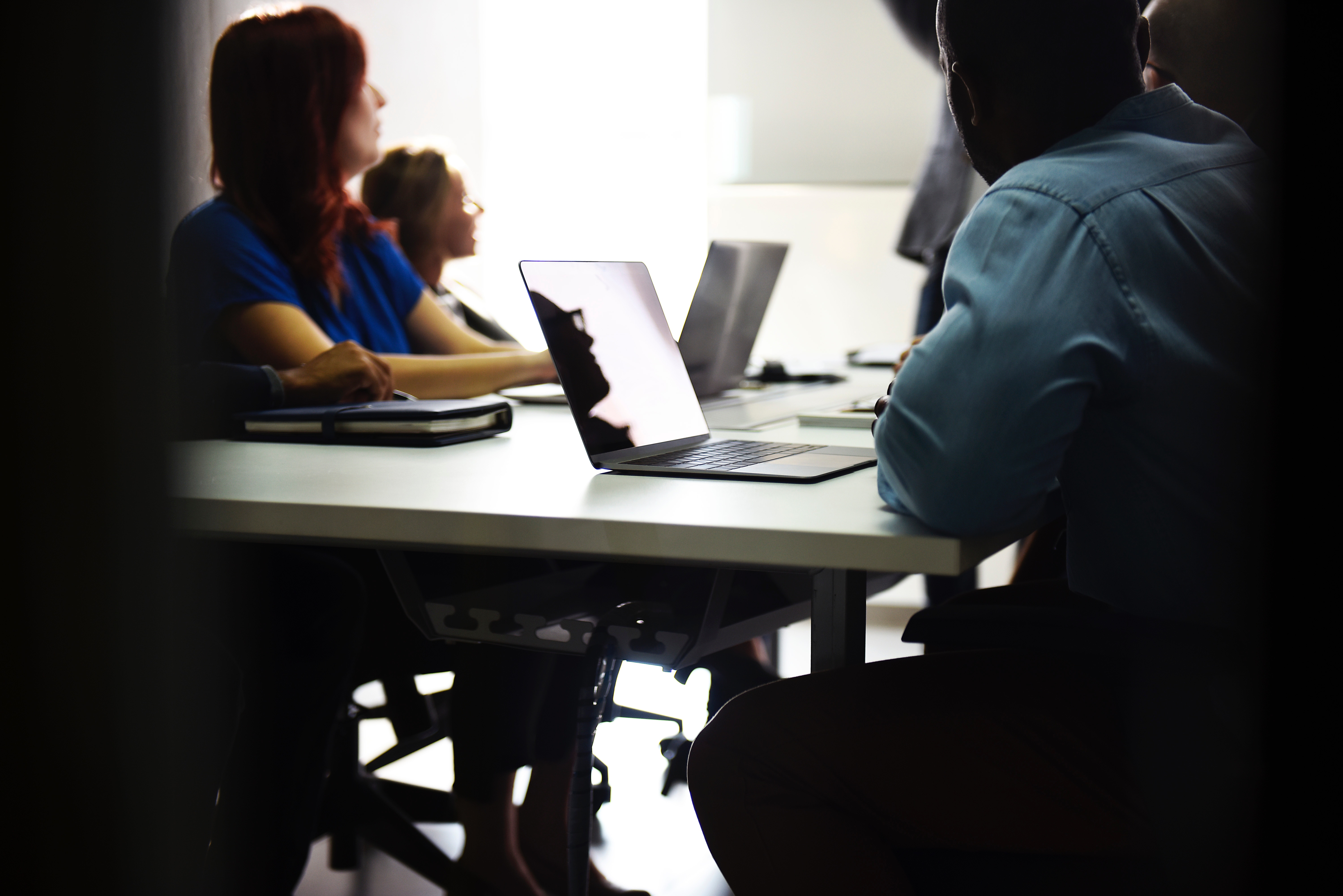 A team of employees at a meeting and sitting at a conference table 