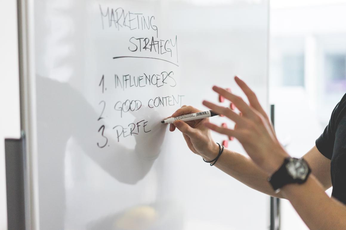 A hand writing on a white board