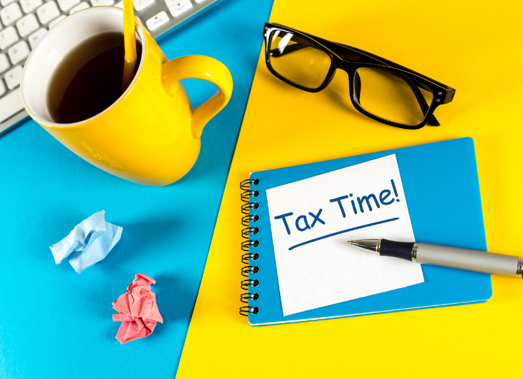 Image of a desk with a sticky notes with the words Tax Time! image link to story