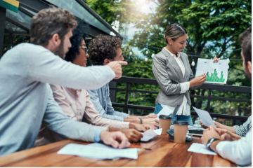 Photo of group discussing a business graph. 