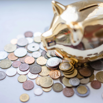 Piggy bank surrounded by a lot coins