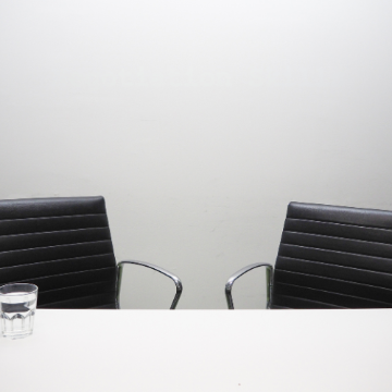 Photo of two empty desk chairs facing each other
