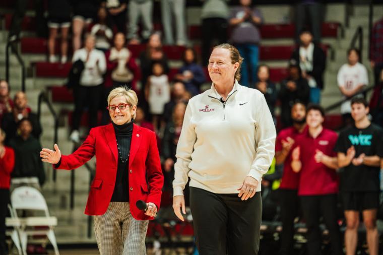 President Julie Sullivan smiles and waves walking next to Heather Owen 