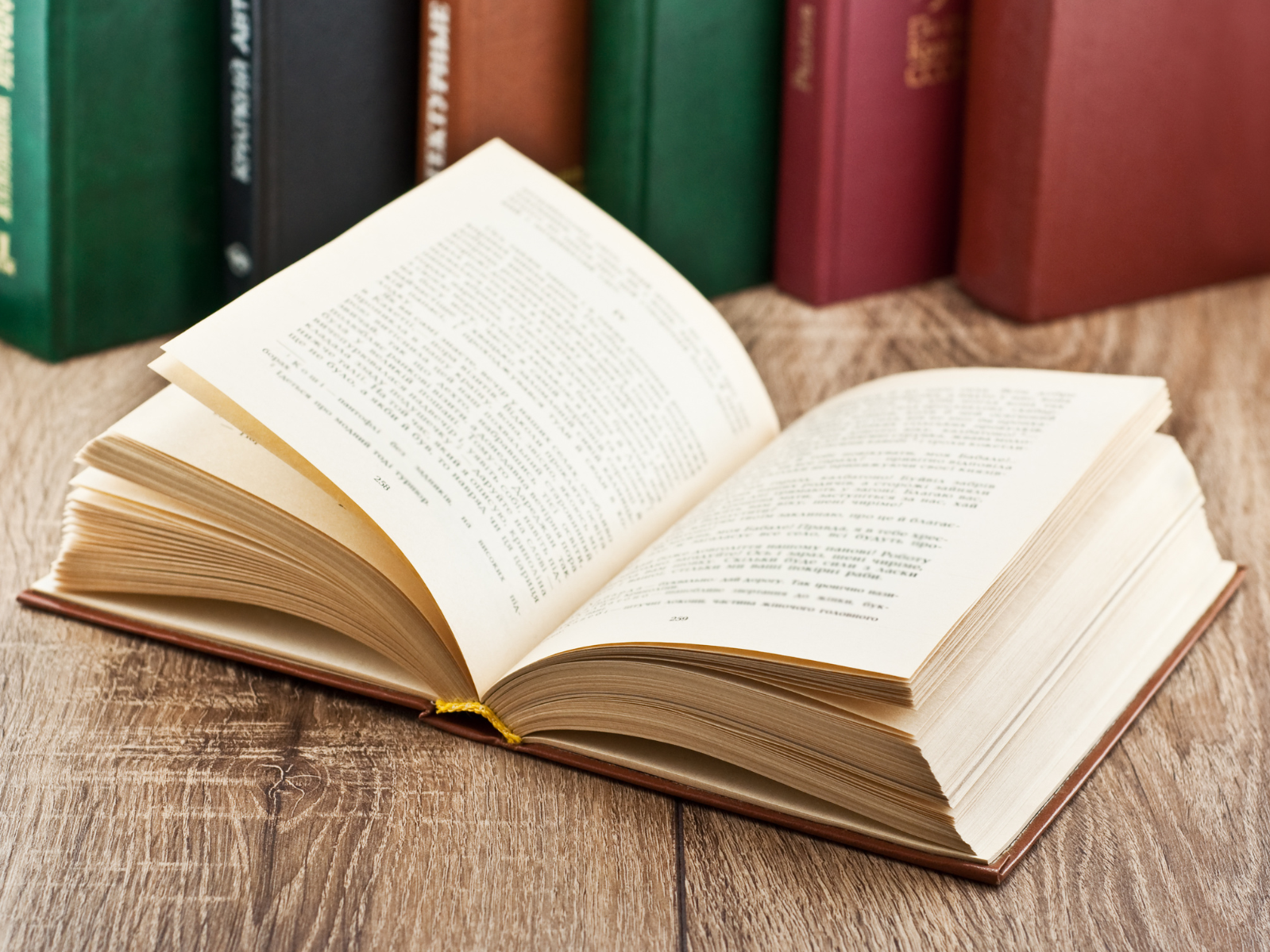 Open book in front of many books