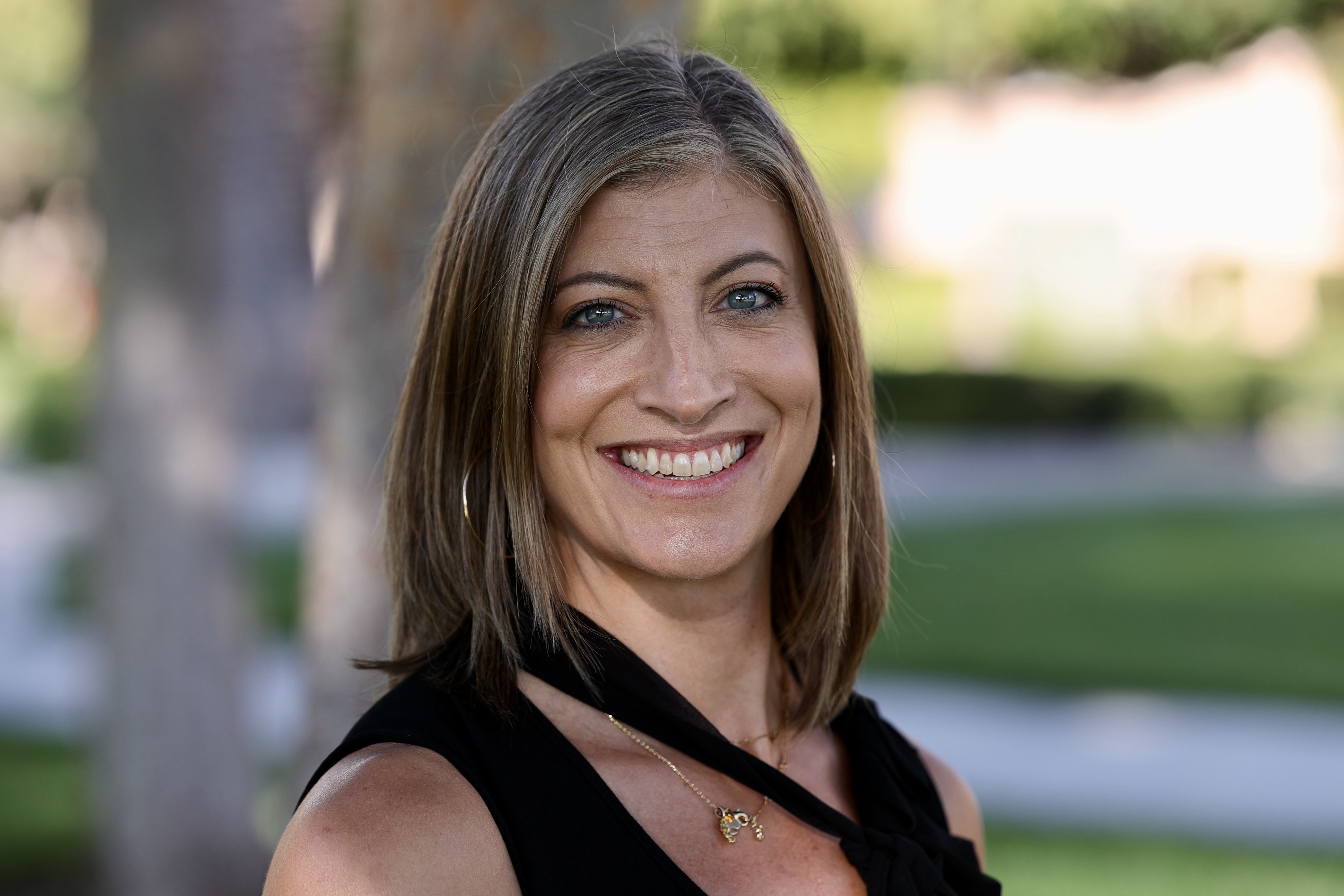 Woman Smiling at Camera in front of tree