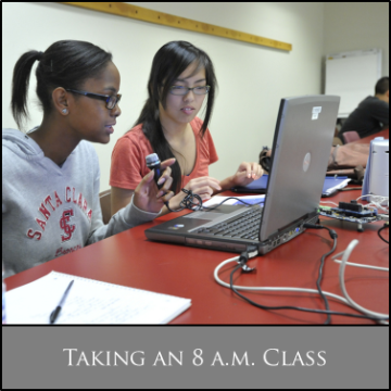 Students working at a table with laptops and notebooks, text reads 