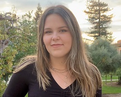 Woman with long blonde hair in a dark top.