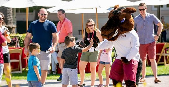 Young boy giving a High 5 to Bucky the Bronco.
