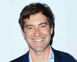 Portrait of a smiling man in a blue sport coat.