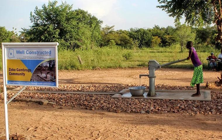 Person pumping water from a well.