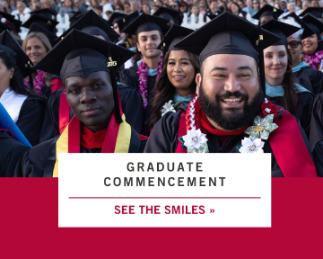 Graduates smiling at Commencement ceremony.