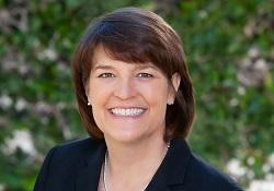 Dark-haired woman in a dark blazer.