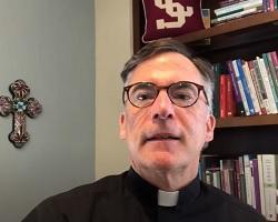 Fr. O'Brien sitting in front of a book shelf.