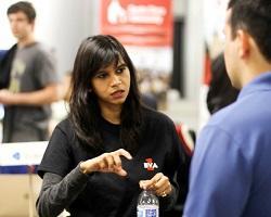 Woman in a black shirt talking to a man in a blue shirt.